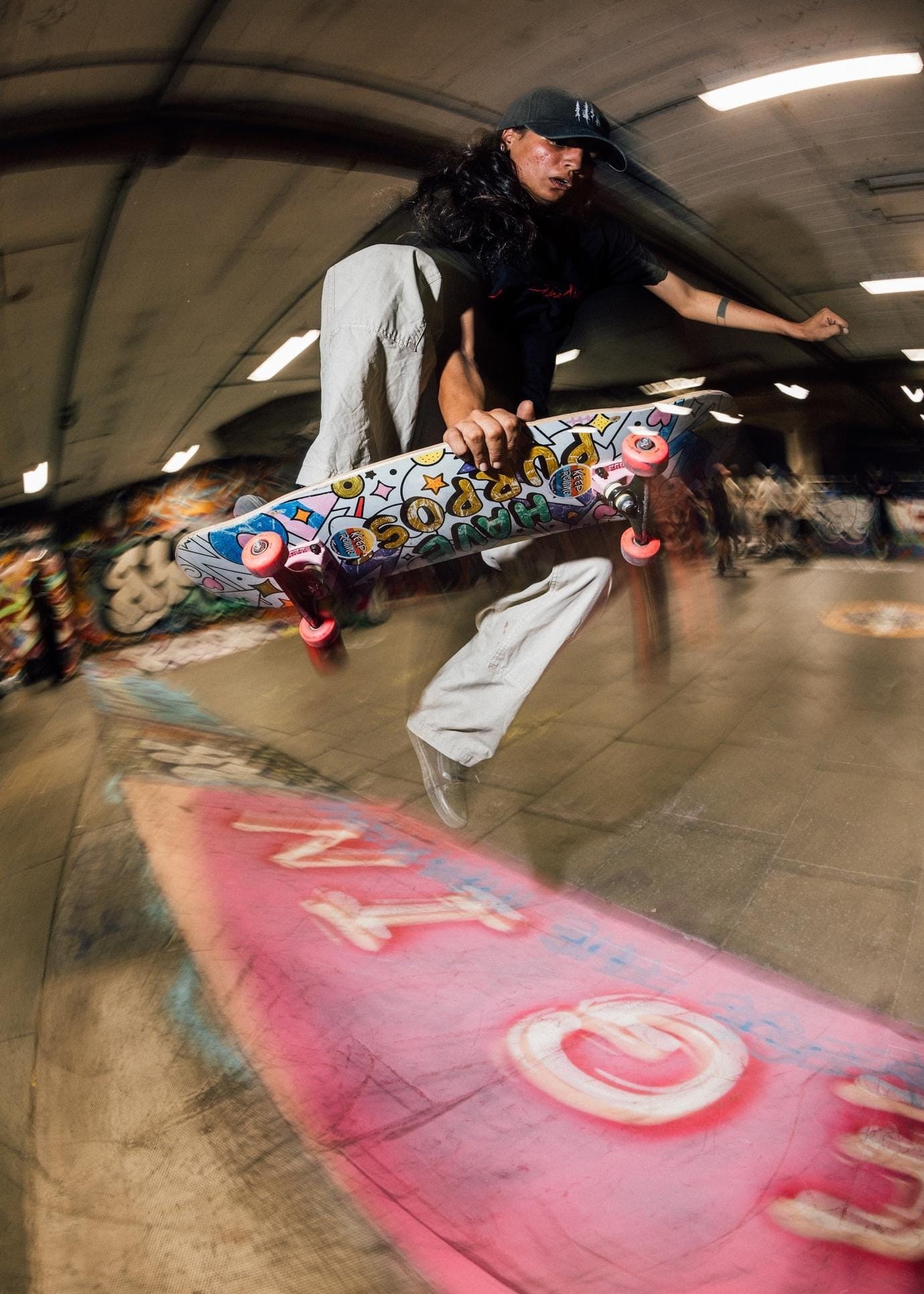 Houda Ait Lahcen performing a trick, one hand on her board, at Southbank