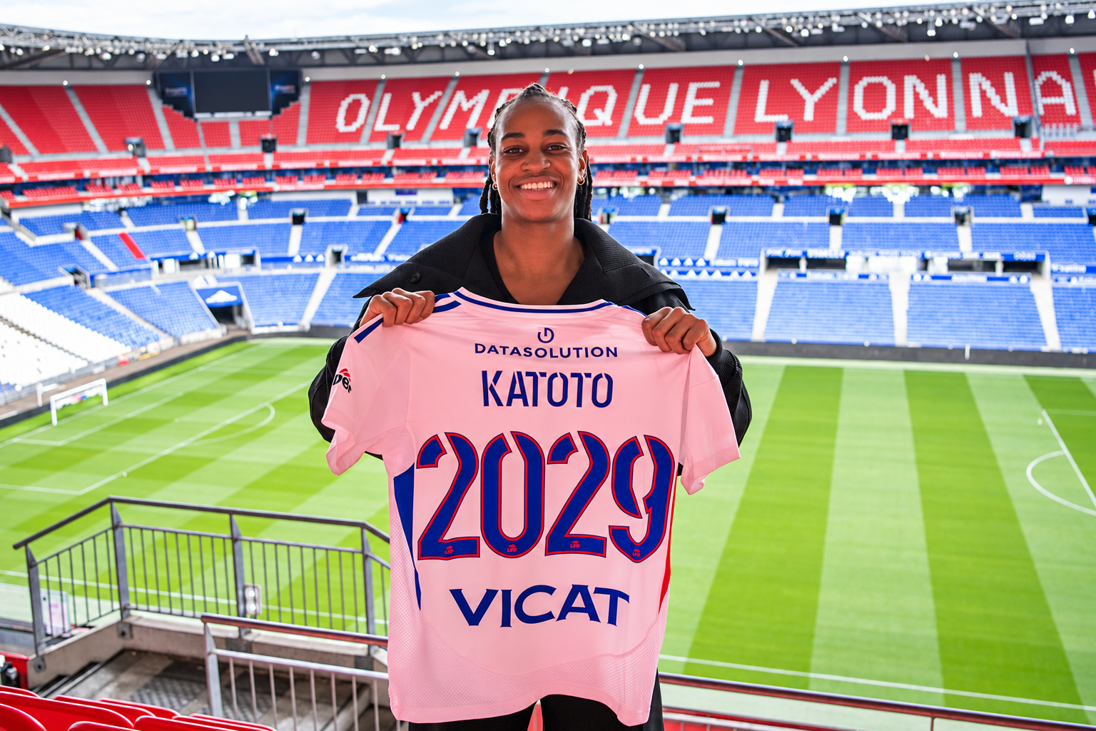 Marie-Antoinette Katoto smiles in the Lyon stadium as she presents her shirt